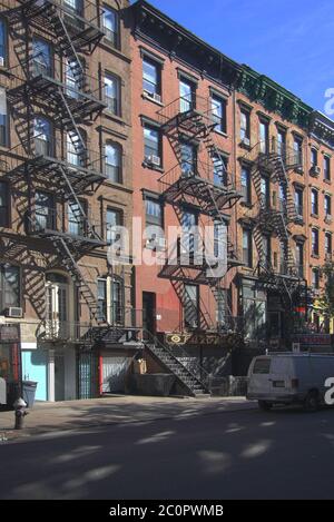 New York City apartment with external fire escape stairs on the front brickwork facade on a summers day in October in Manhattan Stock Photo