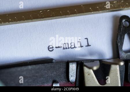 Typing the word “e-mail” on a vintage typewriter. Close up, selective focus. Stock Photo