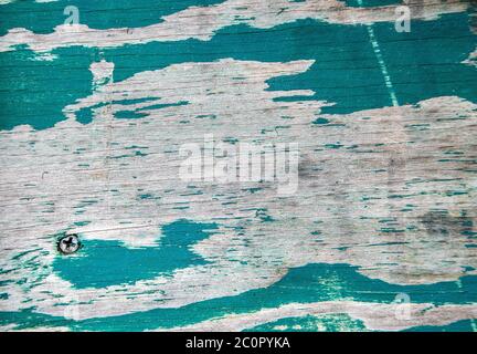 close up of turquoise peeling paint on wood with screw head Stock Photo