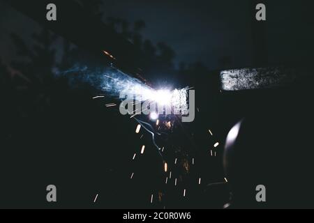 Worker welder working welding steel safety mask . Industrial Welder With Torch and Protective Helmet Stock Photo