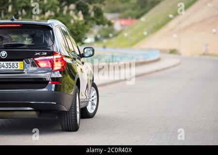 GRODNO, BELARUS - JUNE 2020: BMW X3 II F25 2.0i xDrive rear outdoors on sunny road background of summer city promenade foliage landscape with Stock Photo