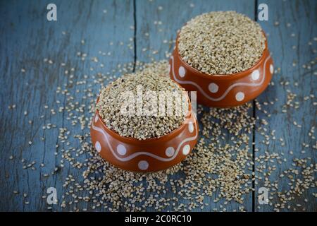 Sesame seeds in clay pot on wooden background Stock Photo