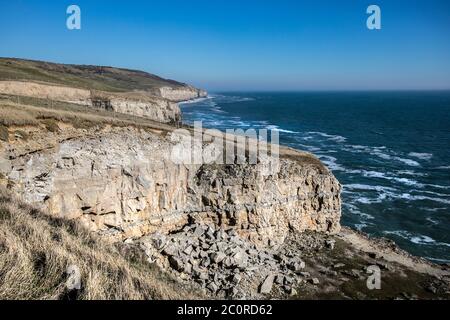 Crumbling cliffs in Dorset with rock strata on Jurassic Coast, with rough seas Stock Photo