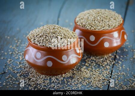 Sesame seeds in clay pot on wooden background Stock Photo