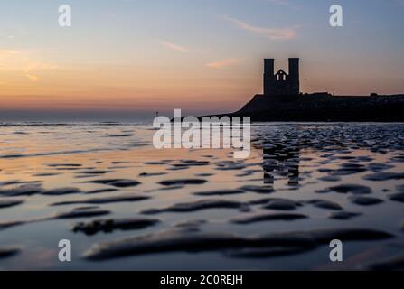 Silhouette of medieval Reculver Towers at sunrise, Kent Stock Photo