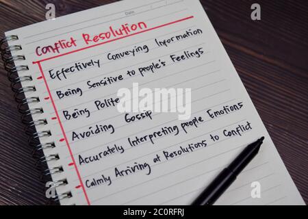 Conflict Resolution write on a book with keywords isolated wooden table. Stock Photo