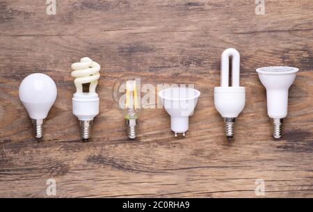 Different kinds of light bulbs on wooden background Stock Photo