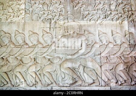 Ancient Khmer bas relief carving showing a row of Hindu gods, devas, pulling on the snake Vasuki. Legend of the churning of the Ocean of Milk, Angkor Stock Photo