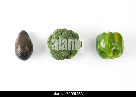 Broccoli, green bell pepper, avocado. Vegetable creative layout on green background. Stock Photo