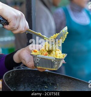 Foam in the tray. hand holding Spoon food in the foam tray ,streetfood Stock Photo