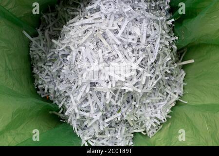 A detail of shredded domestic documents and paperwork in a waste paper bin lined with green polythene bag, a precaution against identity theft and to ensure one's personal data is protected from fraud, on 12th June 2020, in London, England. Stock Photo