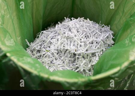 A detail of shredded domestic documents and paperwork in a waste paper bin lined with green polythene bag, a precaution against identity theft and to ensure one's personal data is protected from fraud, on 12th June 2020, in London, England. Stock Photo