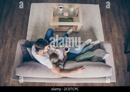 High angle above view photo of domestic pretty charming lady guy couple relaxing sit comfy couch staying home good mood quarantine hugging glad Stock Photo