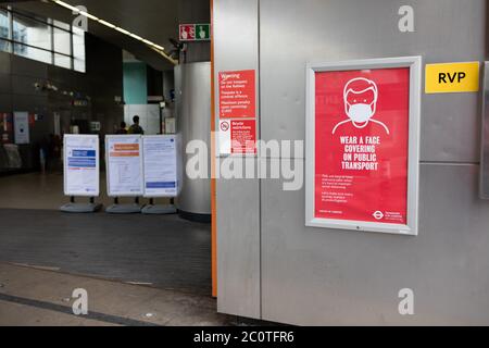 Wear a face covering on public transport poster outside Shoreditch High Street railway station, East London Stock Photo