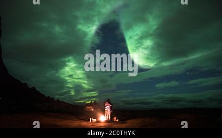 A couple in love embrace under the northern lights in Norway. Stock Photo