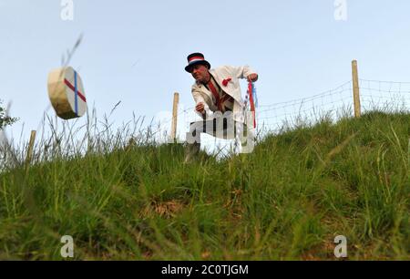 The Cheese Rolling Master of Ceremonies Jem Wakeman rolls the ceremonial cheese down Cooper's Hill, Gloucestershire just before 5.30am Stock Photo
