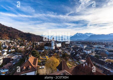 Stunning aerial panorama view of Thun cityscape and Aare river flowing to Lake Thun from Thun castle, with Swiss Alps mountain peaks on Bernese Oberla Stock Photo