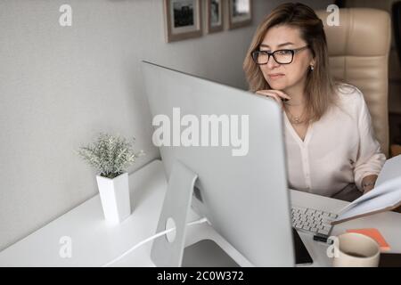 Beautiful business lady working on computers at home Stock Photo