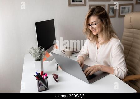 Beautiful business lady working on computers at home Stock Photo