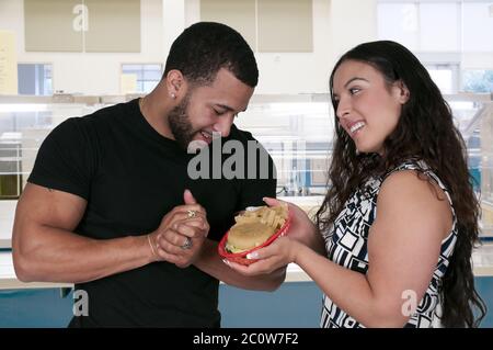 Woman Giving Hamburger to a Man Stock Photo