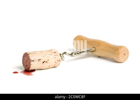 classic wooden corkscrew with cork attached in puddle of red wine, isolated on white Stock Photo