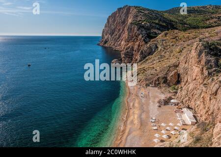 Beautiful Vasili beach in Balaklava, Sevastopol, Russia. View from the top of the rock. azure sea, sunny day clear sky background. Copy space. The con Stock Photo