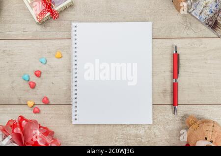 Notepad, pen, candy and teddybear on wooden table Stock Photo