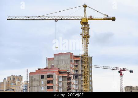 Construction of a high-rise residential building with a crane and workers Stock Photo