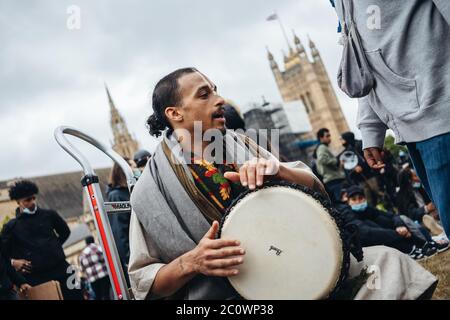 London / UK - 06/06/2020: Black Lives Matter protest during lockdown coronavirus pandemic. Drummer playing music at the march Stock Photo
