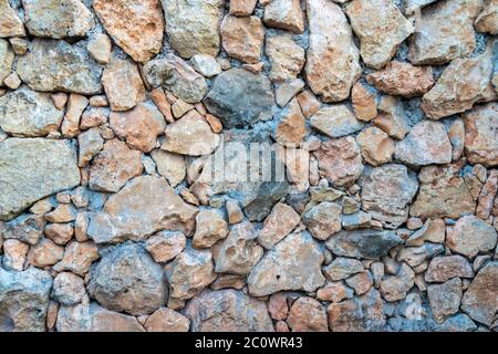 Background of limestone masonry. The surface is decorated with natural material. The wall is made of wild stone. Stock Photo