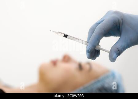 Skin care-a rejuvenation procedure using Botox injections. Squirt close-up and female face blurred background Stock Photo