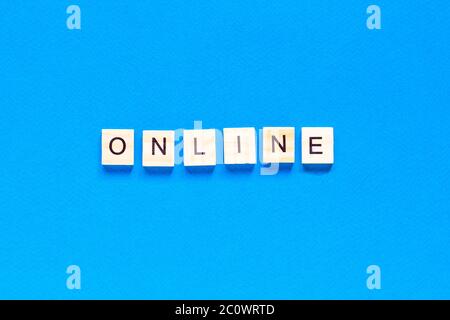 Word Online made with wooden letterpress cubes on blue background. ONLINE written on wood cubes. Conceptual. Expanding business online. Expanding busi Stock Photo