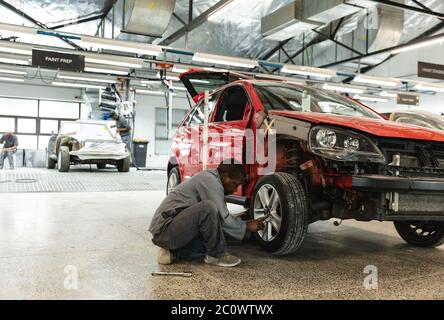 African American mechanic working on a car wheel Stock Photo