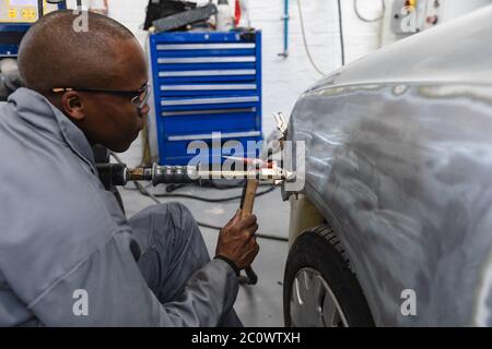 African American mechanic man working on a car Stock Photo
