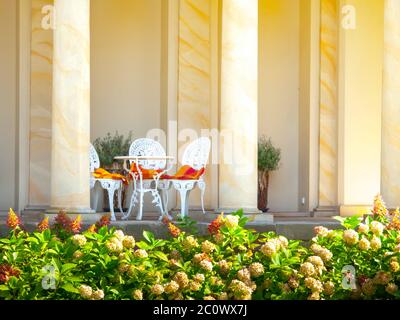 Romantic set of table and white chairs in a garden archway cafe or restaurant. Prefect beautiful place for relax or romantic date - rendez vous. Stock Photo