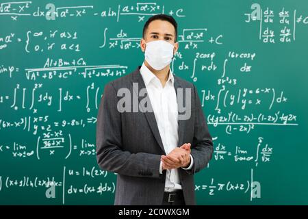 University Professor Standing In Class Wearing Face Mask Stock Photo