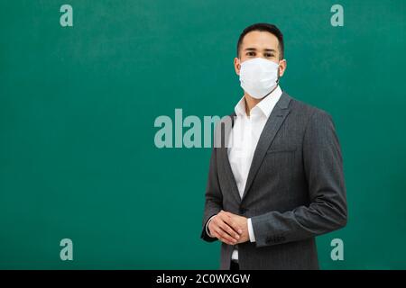 School Teacher Standing In Class Wearing Face Mask Stock Photo