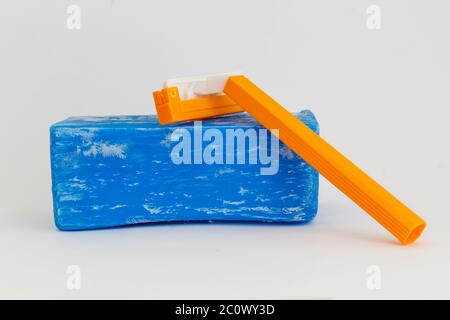 Blue Washing Soap and Orange Shaving Razor on Gray Background Stock Photo