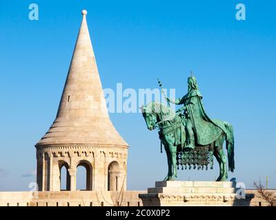 Mounted statue of Saint Stephen I, aka Szent Istvan kiraly - the first king of Hungary at typical white rounded tower of Fisherman's Bastion in Buda Castle in Budapest, Hungary, Europe. Sunny day shot with blue sky on the background. Stock Photo