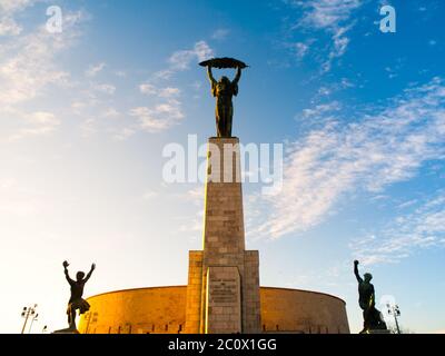 Liberty Statue monument at Citadella on Gellert Hill in Budapest, capital city of Hungary, Europe. Sunny evening view with blue sky on background. Stock Photo