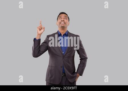 Businessman Poiting Up Isolated. Indian Man Standing Watching Up Stock Photo