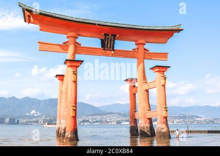 Little girl at the Itsukushima shrine great orange gate O-torii at the Miyajima island in Hiroshima Japan Stock Photo