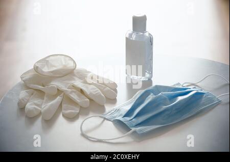 Protective devices to go out safely during viral emergency, Coronavirus COVID-19 pandemic: disposable surgical mask, latex gloves, hand sanitizer gel. Stock Photo