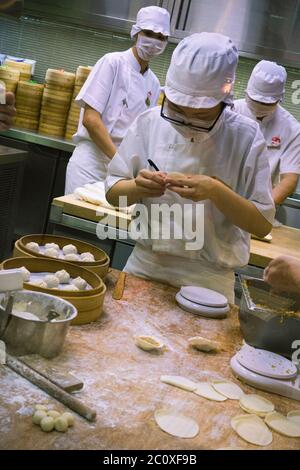 Cookers at works at Din Tai Fung open kitchen. Marina Bay Sands. Singapore Stock Photo