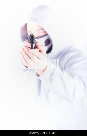 The man in the hood goes with gun in hand Stock Photo