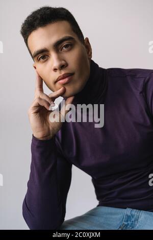 Portrait of pensive man looking at camera. Handsome African American fashion model posing for pictures in studio isolated on background Stock Photo
