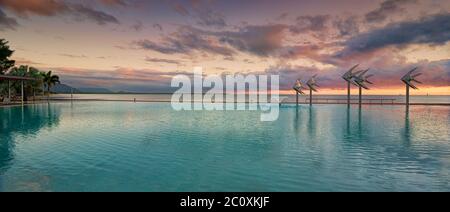 Storm clouds brewing at sunrise on the Cairns Esplanade public swimming lagoon on the edge of the Great Barrier Reef in Queensland, Australia. Stock Photo