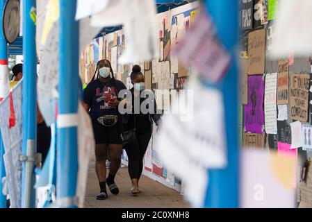 Washington, United States. 12th June, 2020. People walks past a collection of signs following weeks of protest against the death of George Floyd, near Lafayette Park and the White House in Washington, DC on Friday, June 12, 2020. Photo by Kevin Dietsch/UPI Credit: UPI/Alamy Live News