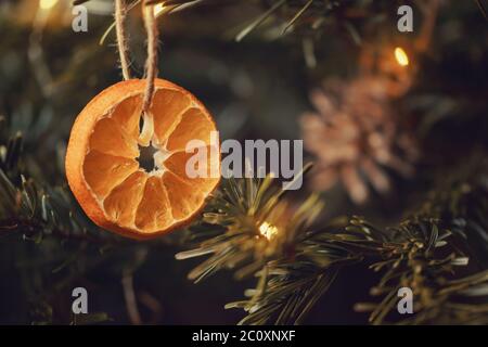 Zero waste christmas concept. Christmas tree decorated with ornaments made of natural materials - slices of dried orange and cones. Stock Photo