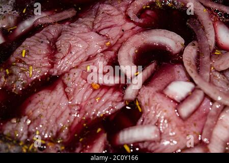 Turkey meat cut into pieces and marinated in red wine with onions and spices. Close-up, surface texture Stock Photo